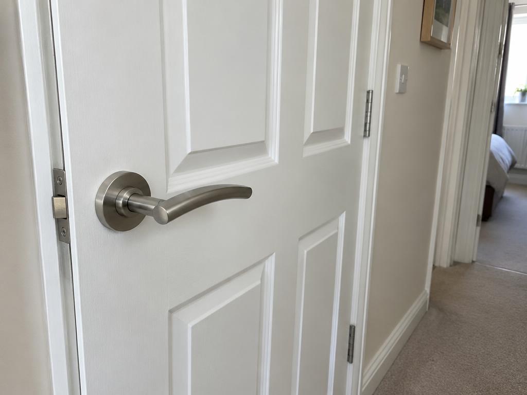 White panelled internal door with a brushed chrome lever handle